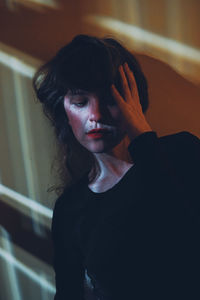 Close-up of woman against wall at home