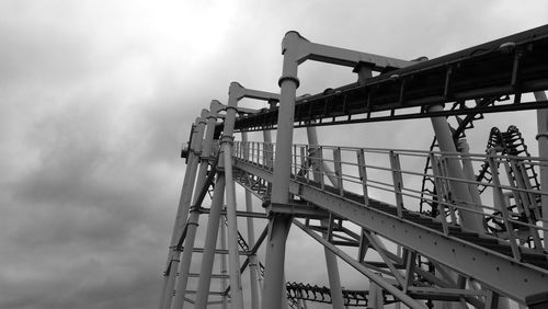 Low angle view of ferris wheel against cloudy sky