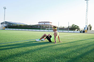 Young man resting on grass after training