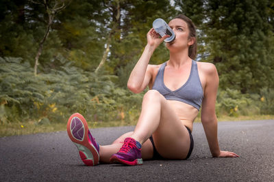 Full length of woman sitting on road