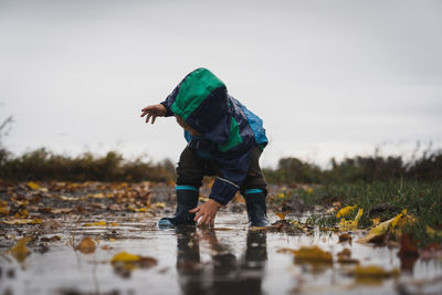 Side view of man standing in puddle