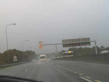 Cars on road against sky in city