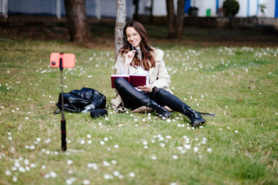 Woman sitting on book in field