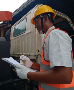 Side view of man working at bus