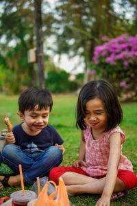 Girl and boy sitting outdoors