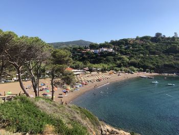 People on beach against clear sky