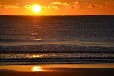 Scenic view of sea against orange sky