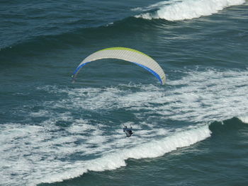 Woman paragliding over sea