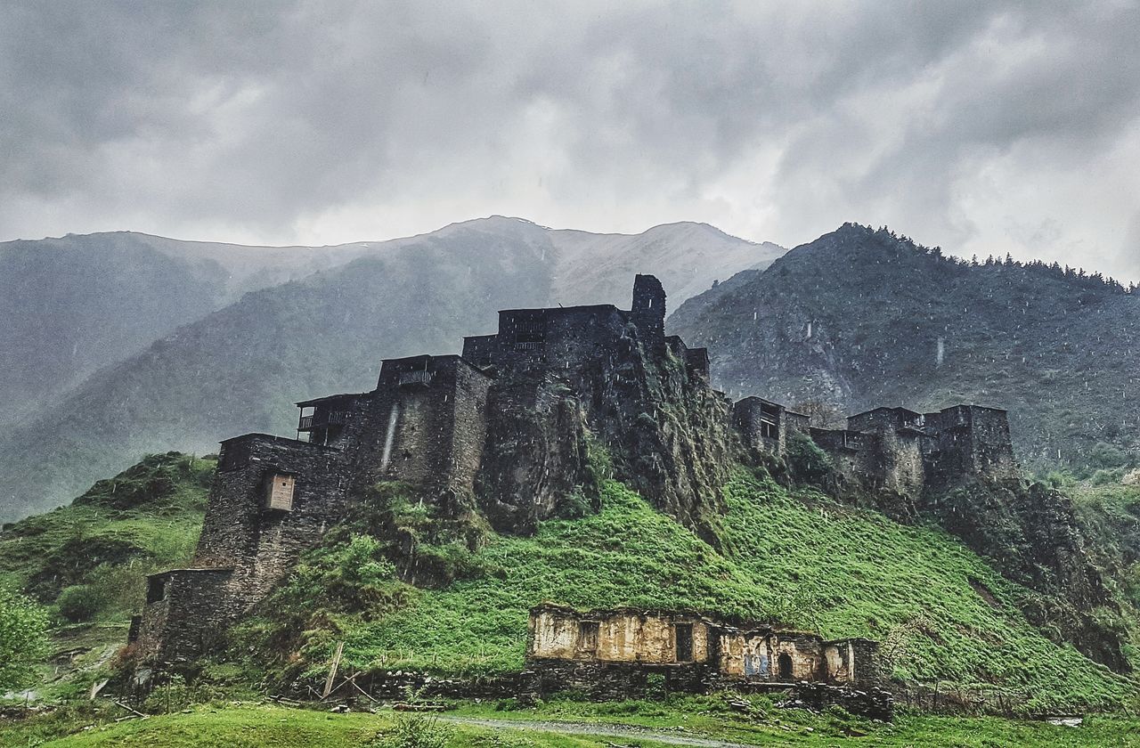 mountain, old ruin, architecture, built structure, history, ancient, the past, day, sky, building exterior, no people, outdoors, travel destinations, abandoned, mountain range, ancient civilization, nature, scenics, low angle view, fog, beauty in nature, landscape