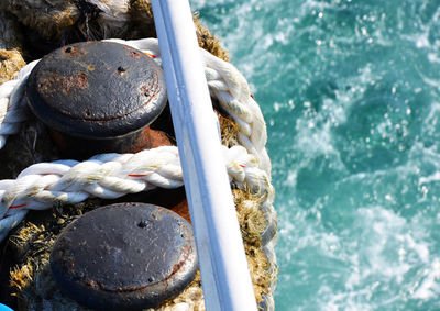 High angle view of rope tied to boat moored at harbor