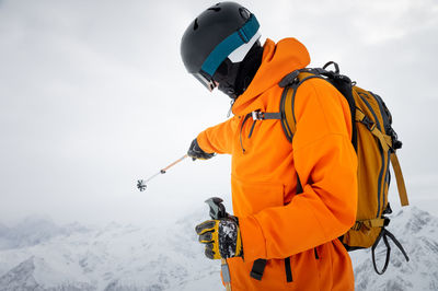 Portrait of a young adult in a ski helmet and goggles, with high