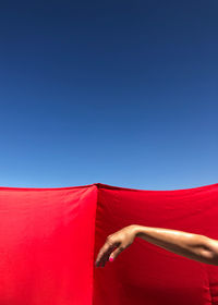 Low angle view of woman against blue sky