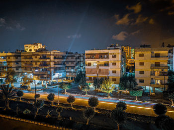 High angle view of illuminated buildings against sky at night