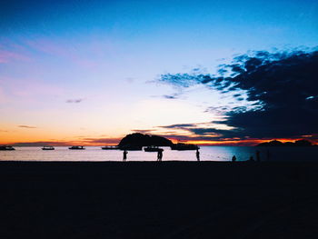 Silhouette man on beach against sky during sunset