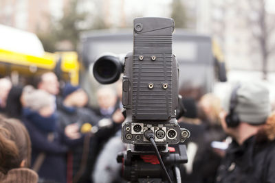 Close-up of camera against crowd