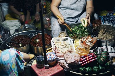 Midsection of woman preparing street food at night