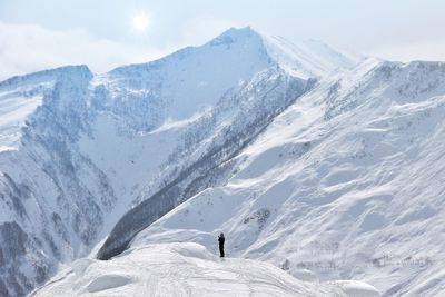Man standing on snowcapped mountains against sky