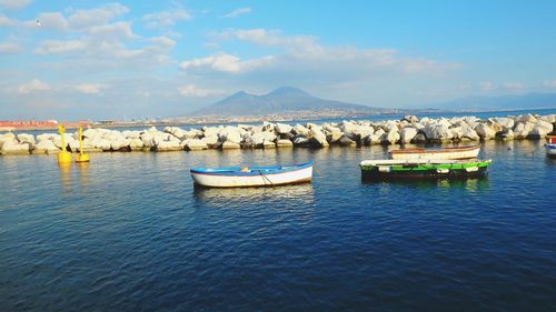 Boats moored in lake against sky