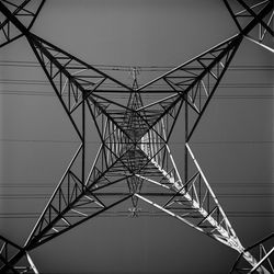 Low angle view of electricity pylon against clear sky