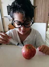 Girl holding apple on table