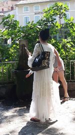 Rear view of woman standing against plants