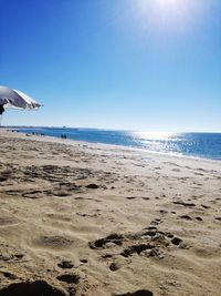 Scenic view of beach against clear blue sky