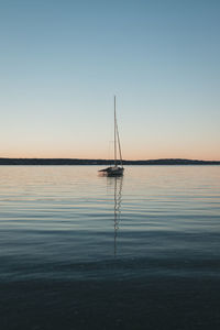 Sailboat in sea against clear sky