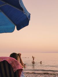 Rear view of woman on beach during sunset