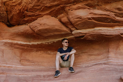 Portrait of young man sitting on rock