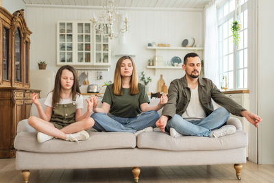 Portrait of smiling family sitting on sofa at home