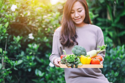 Young woman holding ice cream outdoors