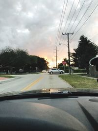 Road by trees against sky