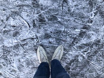 Low section of man standing on snow covered land