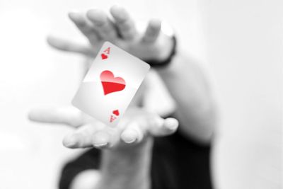 Close-up of hand holding heart shape over white background