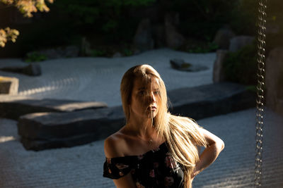 Portrait of young woman standing outdoors