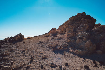 Rock formations on landscape against blue sky