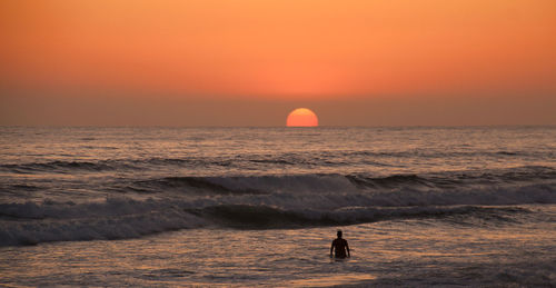 The whole pacific ocean to himself ... lone surfer at sunset.