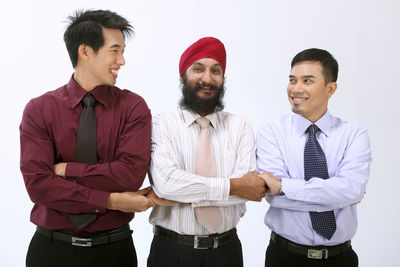 Smiling businessmen standing against white background