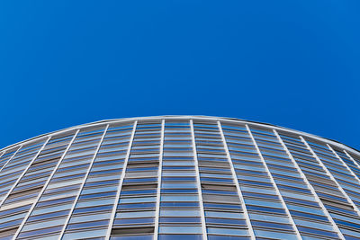 Low angle view of modern building against clear blue sky