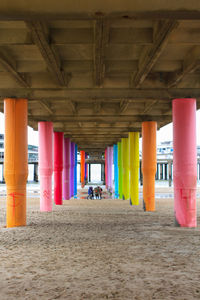 Rear view of people walking under bridge