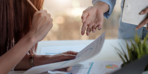 Midsection of woman holding paper with text