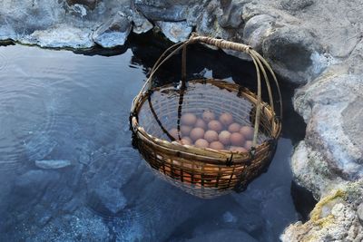 High angle view of wicker basket with brown eggs in hot spring