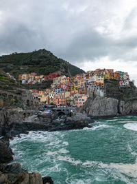 Scenic view of sea by buildings against sky