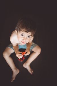 Portrait of cute boy against black background