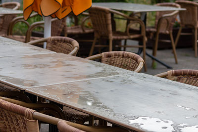 Empty table and empty chairs of summer restaurant or beer garden in summer on rainy day raindrops