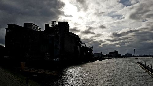 Buildings in city against cloudy sky