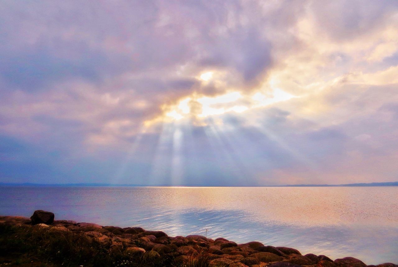 sea, sky, horizon over water, scenics, tranquil scene, water, sunset, beauty in nature, sun, tranquility, cloud - sky, nature, idyllic, sunbeam, cloud, sunlight, rock - object, cloudy, shore, dramatic sky, outdoors, remote, non-urban scene, no people, majestic, calm, orange color, coastline, rock formation, non urban scene, ocean, seascape