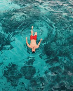 High angle view of shirtless man swimming in sea