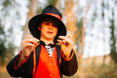 Boy wearing costume during halloween holding blackberries at forest