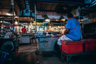 Rear view of man working at market stall